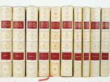 several old books are lined up in a row on a white surface