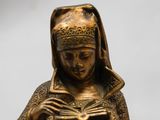 a statue of a woman reading a book on a table