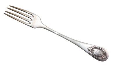 fourchette plaquée argent avec une cuillère et un repose-cuillère sur fond blanc