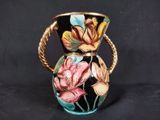 a vase with flowers painted on it on a black background