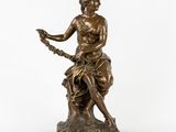 a bronze statue of a woman sitting on a rock