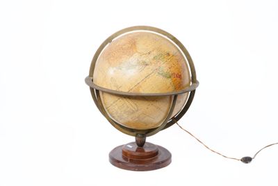 un petit globe terrestre posé sur un socle en bois, sur fond blanc