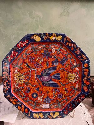 une assiette décorative sur laquelle est représenté un oiseau, posée sur une table