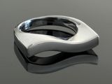 bague en argent posée sur une surface réfléchissante, avec un reflet sur cette surface