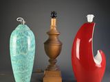 trois vases de couleurs différentes posés l'un à côté de l'autre sur une table