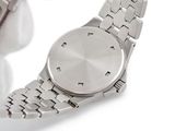 someone is holding a watch in their hand on a white surface