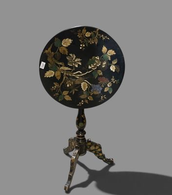 une image représentant une table noire et dorée ornée d'un motif floral