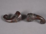 pair of carved wooden elephant heads on a gray surface
