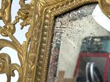 a mirror with a gold frame and a pair of scissors in it