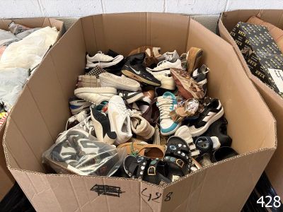 many pairs of shoes in a cardboard box on the floor