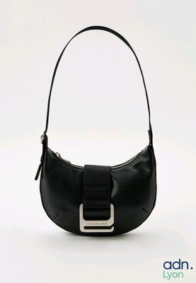 sac à main en cuir noir orné d'une boucle métallique sur fond blanc