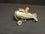 a small toy airplane with a man sitting on top of it