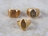 three gold rings with roman numerals on them sitting on a table