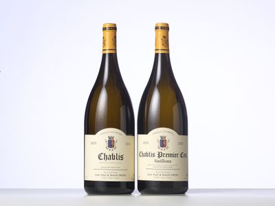 two bottles of white wine sitting on top of a table