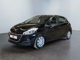 a black car is parked in a room with a white wall