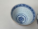 a blue and white bowl with a gold rim on a table