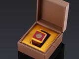 une boîte ouverte contenant une montre, posée sur une surface noire