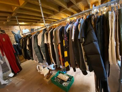 a lot of clothes hanging on a rail in a room