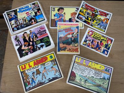 Plusieurs bandes dessinées sont posées sur une table au plateau en bois.