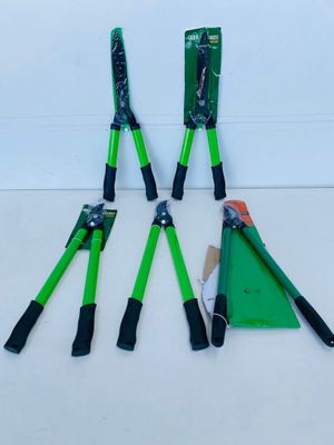 four green and black garden tools sitting on top of a white surface