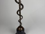 une statue en bronze représentant un serpent surmonté d'un bâton