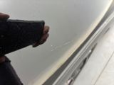 a person holding a piece of cloth near a car door