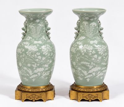 deux vases verts posés sur un socle doré