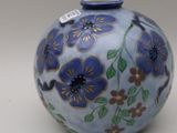 a blue vase with flowers on it sitting on a table