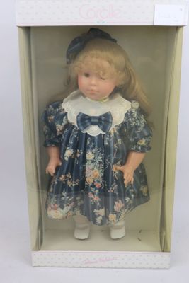 une poupée dans une boîte, vêtue d'une robe bleue