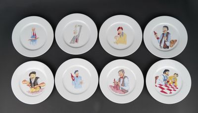 six assiettes blanches ornées de personnages de dessins animés, posées sur un fond noir