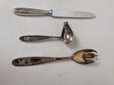 three spoons and a knife on a white surface
