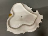 an image of a white shell with a gold handle on a table