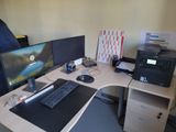 un bureau d'informatique sur lequel sont posés deux écrans et un ordinateur portable