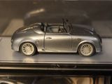a silver toy car on display in a glass case