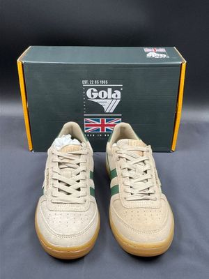 a pair of beige sneakers with green and white laces