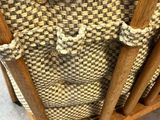 the back of a wooden chair with a woven seat and back