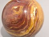 a marble ball sitting on a table with a shadow on the ground