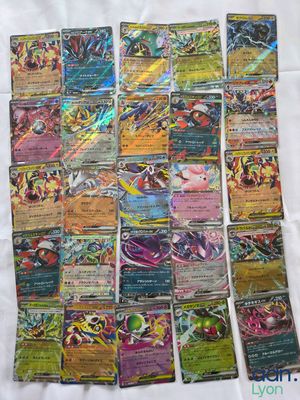 a pile of pokemon cards sitting on top of a white sheet