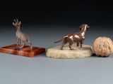 two figurines of dogs and a walnut on a marble base