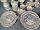a lot of silver dishes and cups on the table