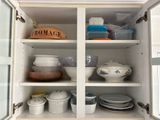 a cabinet with dishes and bowls in it