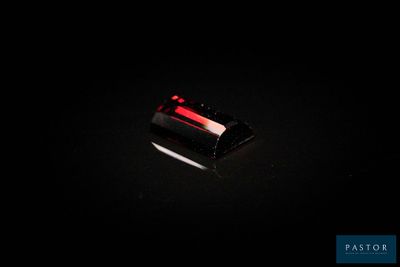 un gros plan d'une pierre rouge sur une surface noire