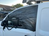 une bâche noire à l'arrière d'une camionnette blanche
