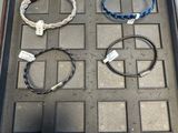 Plusieurs bracelets sont exposés dans une vitrine posée sur une table