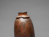 an old wooden vase sitting on top of a gray surface