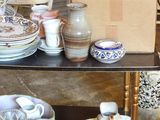 many plates and cups on a shelf in a room