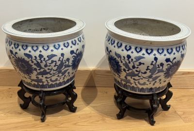 deux vases bleus et blancs posés sur un plancher en bois