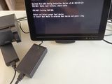 a computer monitor sitting on top of a desk with a charger