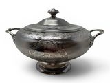 an antique silver plated bowl with handles and a lid on a stand