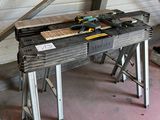 une photo d'un établi dans un garage avec des outils dessus